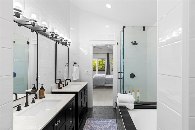 bathroom with tile patterned floors, tile walls, lofted ceiling, a shower with door, and vanity