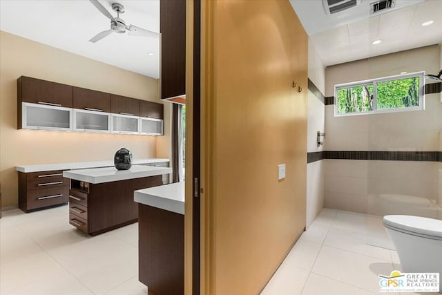 bathroom featuring ceiling fan, vanity, tile walls, tile patterned floors, and toilet