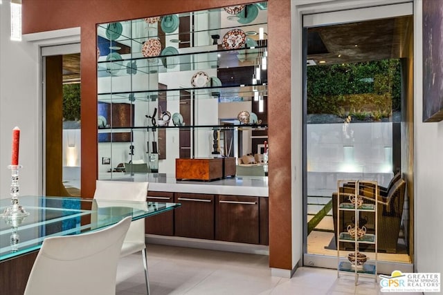 bar featuring dark brown cabinetry and light tile patterned floors