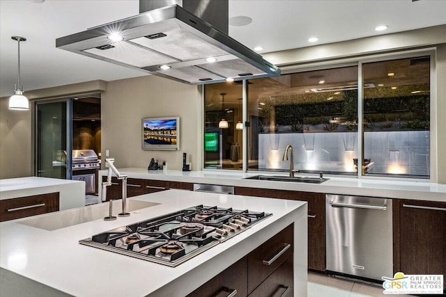 kitchen featuring dark brown cabinetry, stainless steel appliances, sink, island range hood, and hanging light fixtures