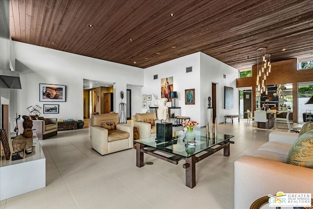 living room featuring a towering ceiling, wood ceiling, and a chandelier