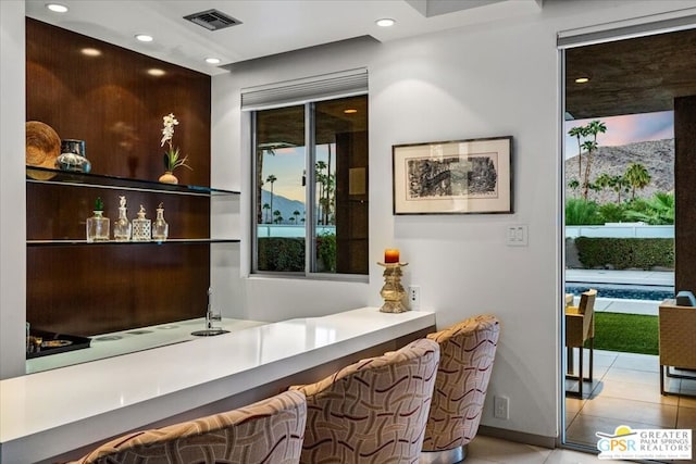 bar featuring plenty of natural light and light tile patterned floors