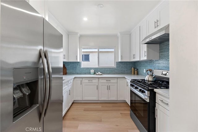 kitchen with tasteful backsplash, white cabinets, stainless steel appliances, and light wood-type flooring