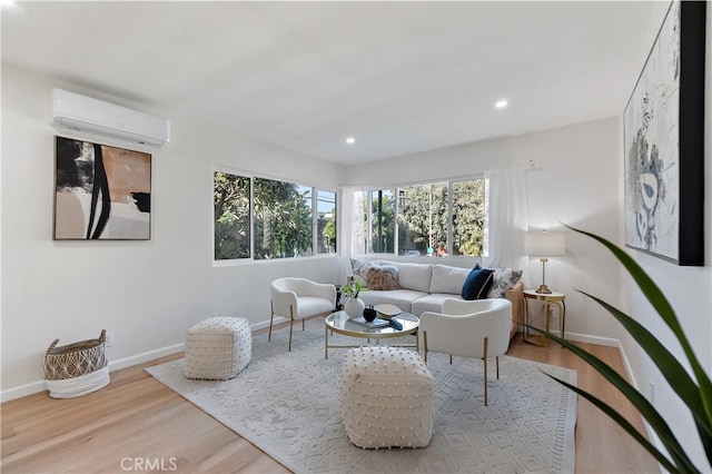 living room featuring a healthy amount of sunlight, light wood-type flooring, and an AC wall unit