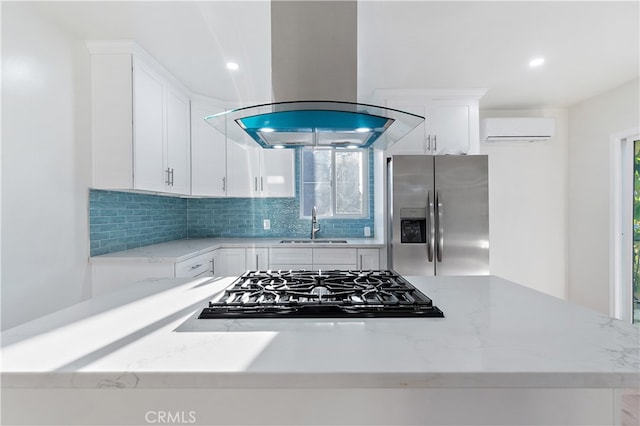 kitchen with island exhaust hood, light stone countertops, an AC wall unit, stainless steel fridge with ice dispenser, and white cabinetry