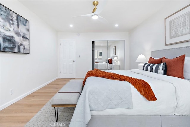 bedroom with ceiling fan, a closet, and light hardwood / wood-style floors