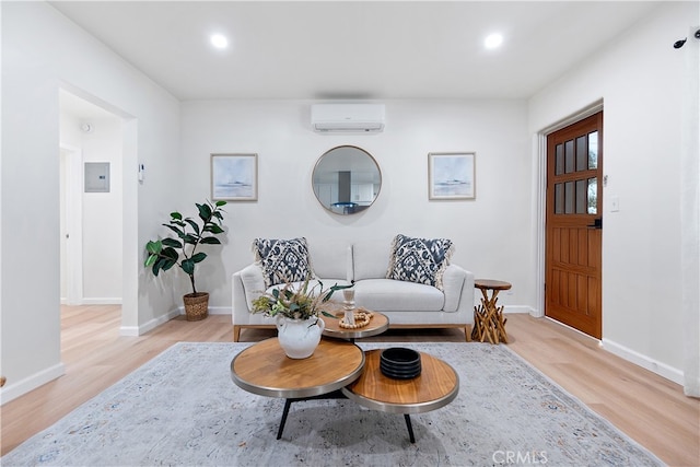 living area featuring a wall unit AC, electric panel, and light hardwood / wood-style floors