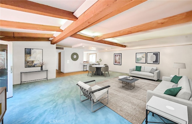 carpeted living room with visible vents and lofted ceiling with beams