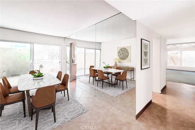 dining area with a wealth of natural light, baseboards, and light tile patterned flooring