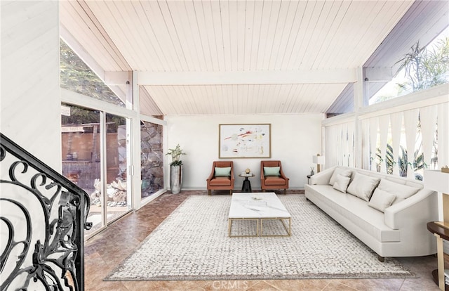 living room with lofted ceiling with beams and baseboards