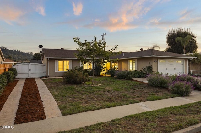 view of front of property featuring a garage and a lawn