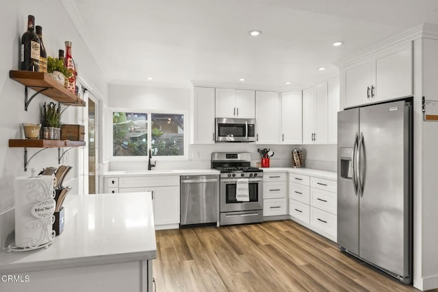 kitchen with white cabinets, stainless steel appliances, light hardwood / wood-style floors, and sink