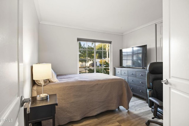 bedroom featuring wood-type flooring and ornamental molding