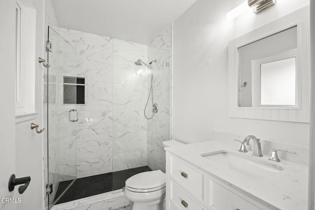 bathroom featuring vanity, toilet, and a shower with shower door