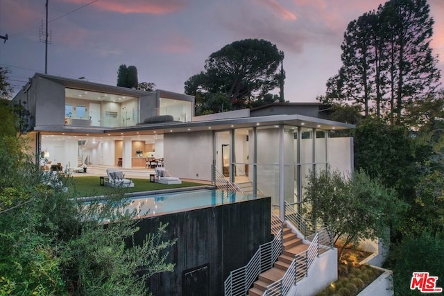 back house at dusk with a patio