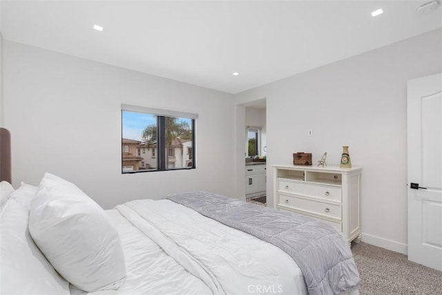 bedroom featuring light carpet and ensuite bath