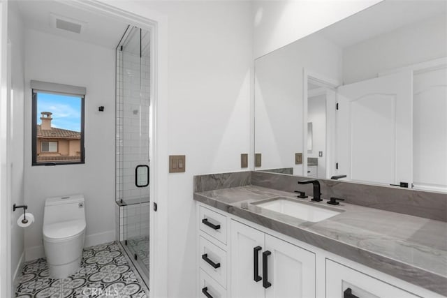 bathroom with tile patterned floors, vanity, toilet, and an enclosed shower