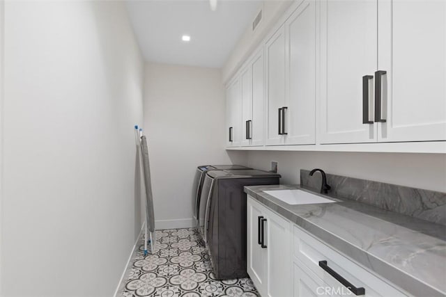 laundry room with washer and clothes dryer, cabinets, and sink