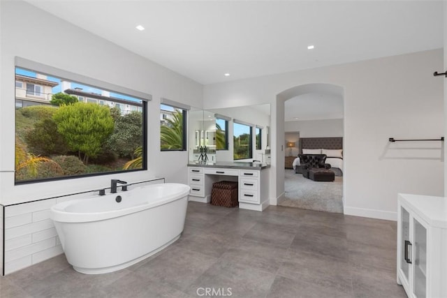 bathroom featuring vanity, a bathtub, and tile walls