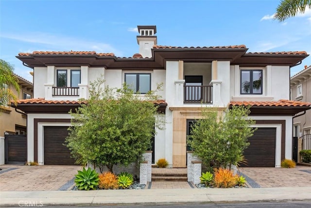 mediterranean / spanish-style house featuring a balcony and a garage