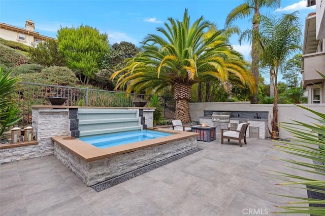 view of swimming pool with an outdoor kitchen, a grill, an in ground hot tub, and a patio