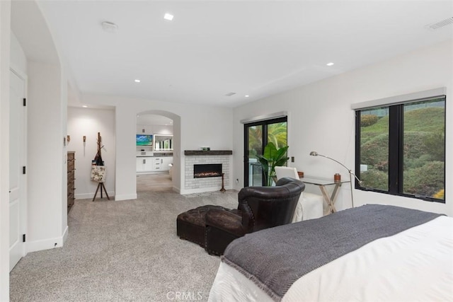 carpeted bedroom with a fireplace