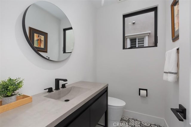 bathroom with tile patterned flooring, vanity, and toilet