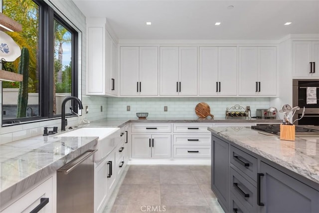 kitchen featuring light stone counters, white cabinetry, and stainless steel appliances