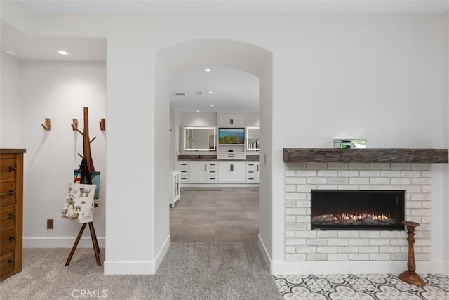 living room featuring a fireplace and light colored carpet