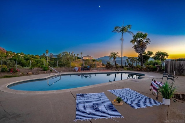 pool at dusk featuring a patio