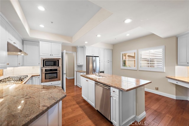 kitchen with light stone counters, appliances with stainless steel finishes, dark hardwood / wood-style floors, and white cabinetry