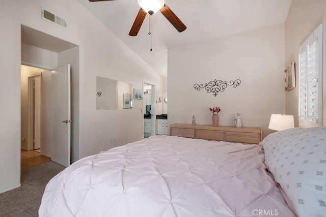 bedroom featuring ceiling fan, ensuite bathroom, high vaulted ceiling, and light carpet