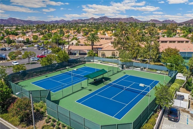 view of tennis court featuring basketball hoop and a mountain view