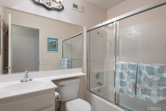 full bathroom featuring vanity, combined bath / shower with glass door, and toilet