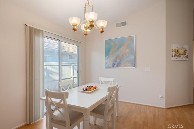 dining space featuring a chandelier and light hardwood / wood-style flooring