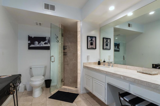 bathroom featuring tile patterned flooring, vanity, toilet, and walk in shower