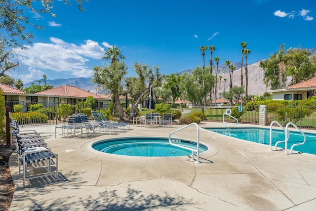 view of swimming pool with a mountain view, a hot tub, and a patio area