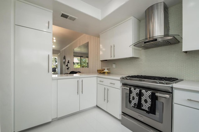 kitchen featuring dishwasher, stainless steel range with gas cooktop, sink, wall chimney exhaust hood, and white cabinetry