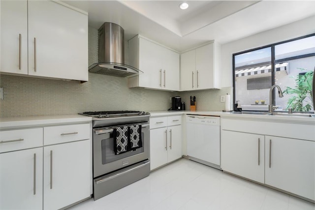 kitchen featuring dishwasher, white cabinets, wall chimney range hood, sink, and stainless steel range