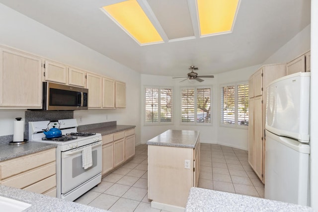 kitchen featuring a kitchen island, light brown cabinetry, ceiling fan, and white appliances