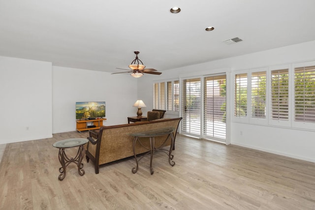 living room featuring light hardwood / wood-style floors and ceiling fan