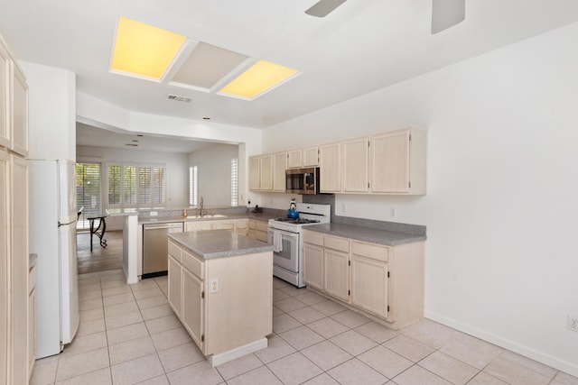 kitchen with a center island, stainless steel appliances, sink, kitchen peninsula, and light tile patterned floors