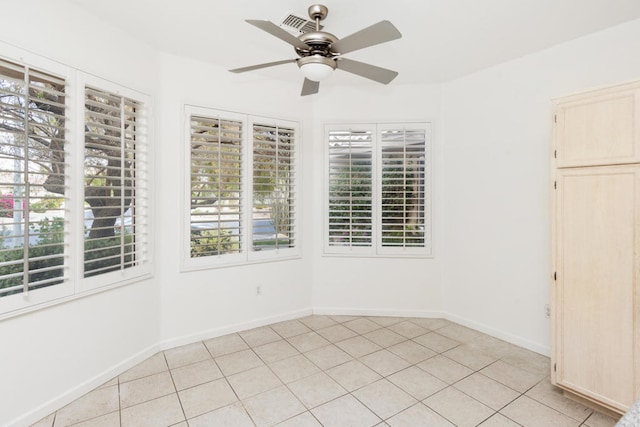 empty room with ceiling fan and light tile patterned flooring