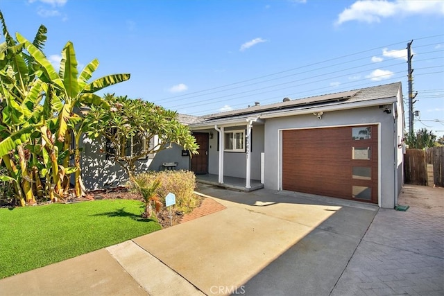 single story home with a garage, solar panels, and a front lawn