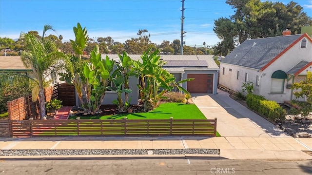 view of front facade with a garage, solar panels, and a front lawn