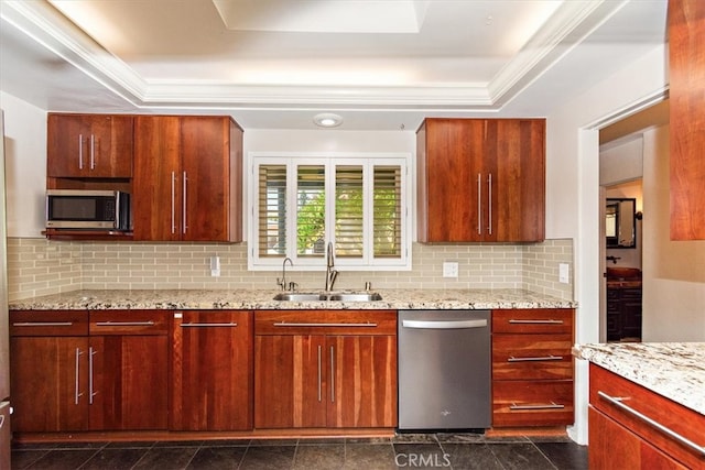 kitchen with a raised ceiling, sink, backsplash, appliances with stainless steel finishes, and light stone countertops