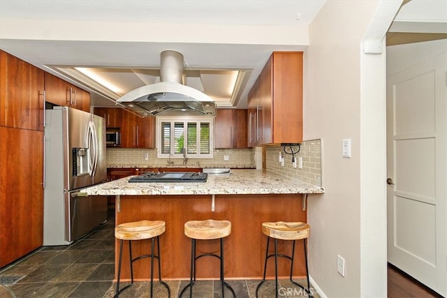 kitchen with decorative backsplash, stainless steel appliances, a breakfast bar, kitchen peninsula, and island range hood