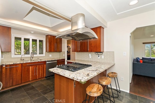 kitchen featuring sink, backsplash, appliances with stainless steel finishes, a kitchen bar, and island range hood