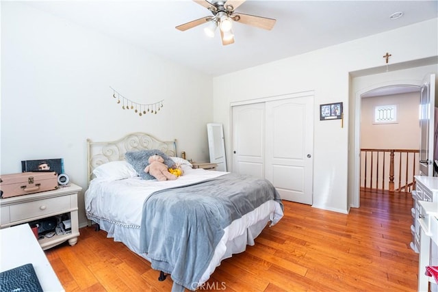 bedroom featuring ceiling fan, a closet, and light wood-type flooring