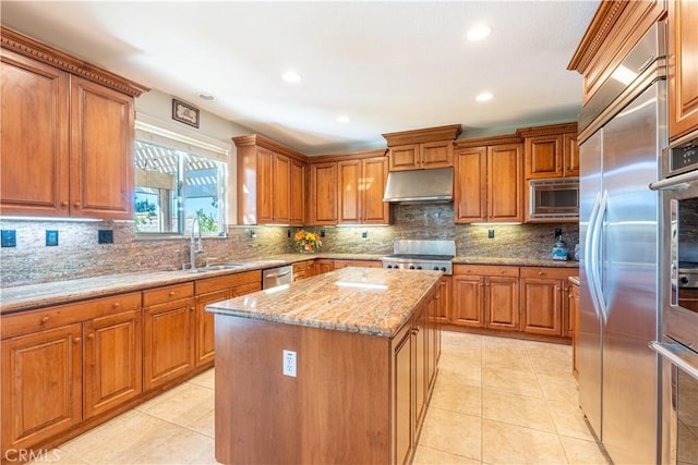 kitchen with light tile patterned flooring, built in appliances, light stone countertops, tasteful backsplash, and a kitchen island